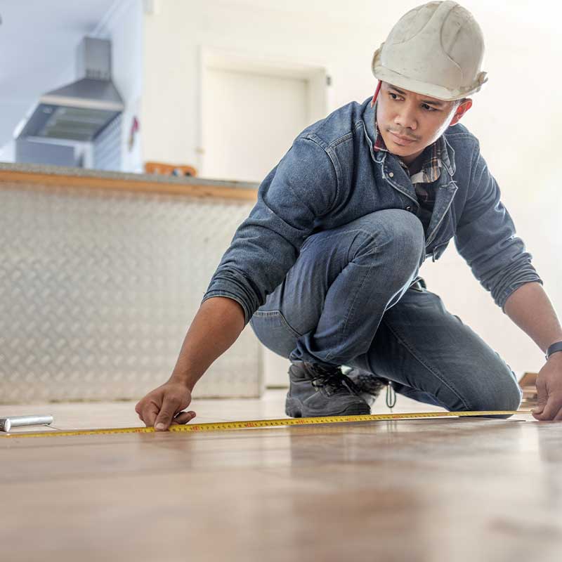 Person measuring floor with tape